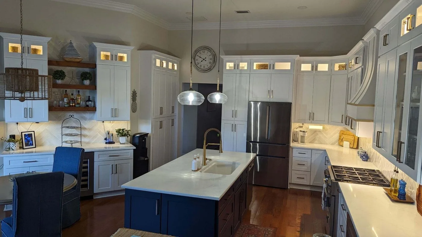 Ponte Vedra kitchen with a painted island, glass fronted cabinets and brass fixtures