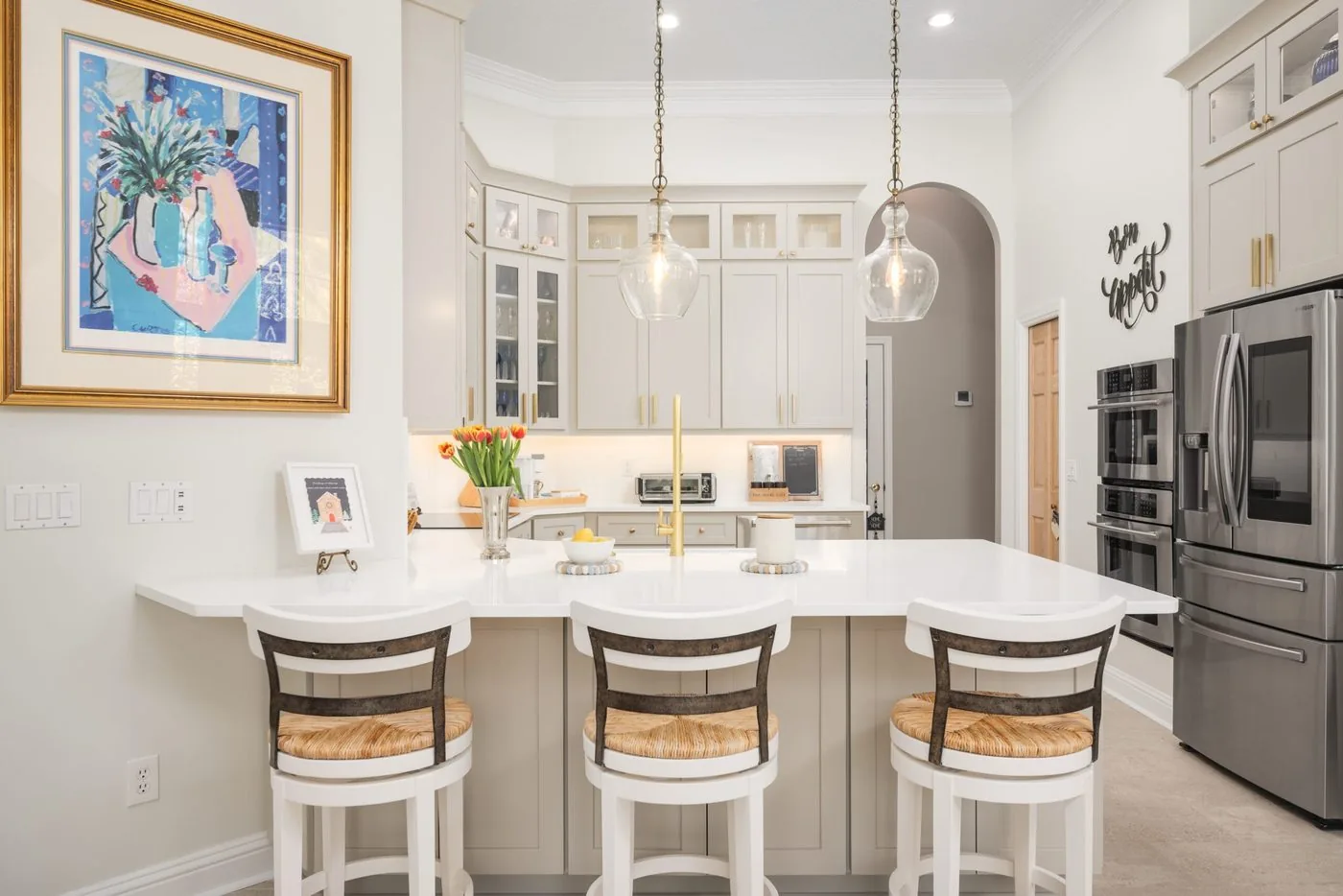 Queens Harbor kitchen with a curved counter, glass pendants and an arched pass through